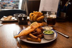 a plate of food with fish and onion rings and fries at The Lindisfarne Inn - The Inn Collection Group in Beal