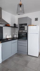 uma cozinha com electrodomésticos brancos e um frigorífico branco em Face à la plage em Bourcefranc