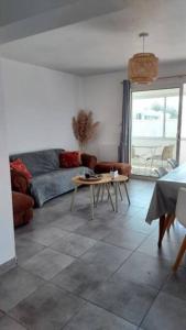 uma sala de estar com um sofá e uma mesa em Face à la plage em Bourcefranc