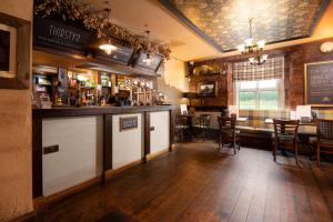 a bar in a pub with a table and chairs at The Lindisfarne Inn - The Inn Collection Group in Beal
