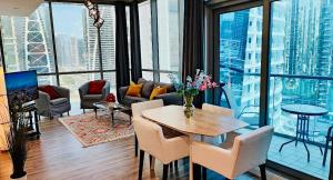 a living room with a table and chairs at Luxe 1BD, boutique apt full lakeview 1m to Metro, Lake & Almas Tower By "La Buena Vida Holiday Homes" in Dubai