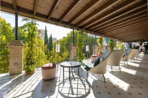 un patio con sedie e un tavolo in vetro sul balcone. di Seda Club Hotel - Small Luxury Hotels a Granada