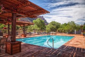 una piscina en un complejo con una montaña en el fondo en Cable Mountain Lodge en Springdale