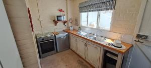 布菲尔斯巴埃Sailaway Beach House的一个小厨房，里面有水槽和炉灶。