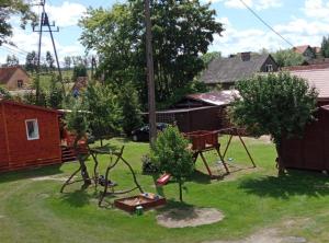 einen Hof mit einer Schaukel und einem Spielplatz in der Unterkunft Owocowe Wakacje - Apartament nad jeziorem in Mikołajki