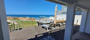 布菲尔斯巴埃Sailaway Beach House的带桌椅和海景的阳台