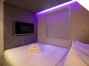a bedroom with two towels on a bed with a tv at Bloc Hotel Birmingham in Birmingham