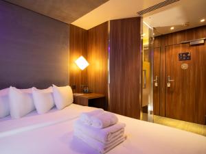 a bedroom with a bed with towels on it at Bloc Hotel Birmingham in Birmingham