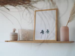 a wooden shelf with a picture and a vase on it at Villa Sayulita Surfhouse in Seignosse