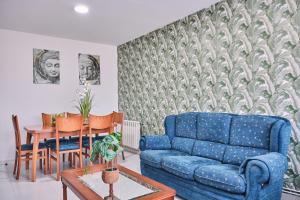 sala de estar con sofá azul y mesa en Peregrina Pensión 6, en O Pedrouzo