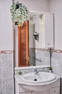 a bathroom with a sink and a mirror at Peregrina Pensión 6 in O Pedrouzo