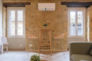 a living room with a table and three chairs at La Rousserolle de Sarlat in Sarlat-la-Canéda
