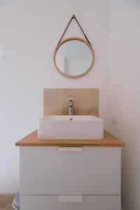a bathroom with a white sink and a mirror at La Rousserolle de Sarlat in Sarlat-la-Canéda +8 photos