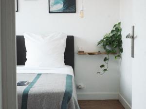 a bedroom with a bed with a pillow and a plant at Villa Sayulita Surfhouse in Seignosse