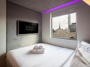 a hotel room with a bed with a tv on the wall at Bloc Hotel Birmingham in Birmingham