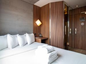 a bedroom with a large bed with white pillows at Bloc Hotel Birmingham in Birmingham