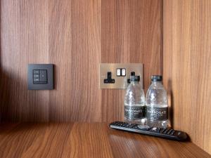 two bottles of water sitting next to a remote control at Bloc Hotel Birmingham in Birmingham
