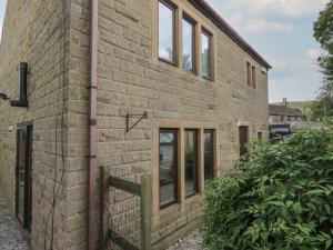 uma casa de tijolos com janelas do lado em Cheshire House em Castleton