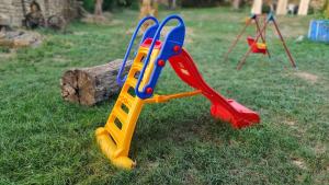 une balançoire colorée sur l'herbe dans l'établissement Къща за гости Румянцево, à Rumyantsevo