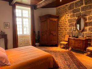 - une chambre avec un lit et un mur en pierre dans l'établissement Commanderie Templière de Cazouls d'Hérault, à Cazouls-d Herault