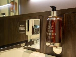 a bottle of soap in a bathroom mirror at Bloc Hotel Birmingham in Birmingham