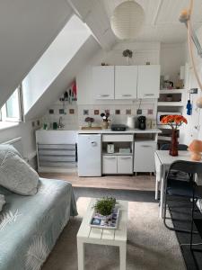 a small kitchen and living room with a couch and a table at 45 Grande Rue bis in Ault