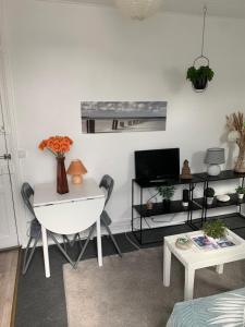 a white living room with a white table and a white chair at 45 Grande Rue bis in Ault