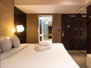 a bedroom with a white bed with towels on it at Bloc Hotel Birmingham in Birmingham