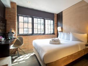 a hotel room with a large bed and a desk at Bloc Hotel Birmingham in Birmingham