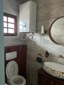 ein Badezimmer mit einem WC, einem Waschbecken und einem Spiegel in der Unterkunft La Villa Saint Jean in Cotonou