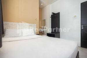 Tempat tidur dalam kamar di One 2 Residence near Slipi Jaya Mall Mitra RedDoorz