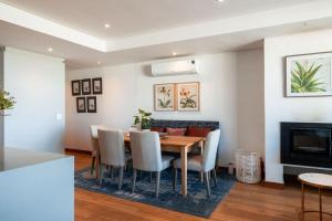 a dining room with a table and chairs and a fireplace at 17 Marine - 3Bedroom Sea-Facing Apt101 in Hermanus