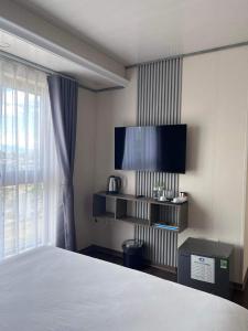een slaapkamer met een bed en een flatscreen-tv bij Thiên Ân Hotel in Thôn Dương Phẩm