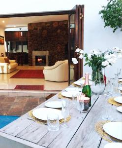 a table with plates and glasses and a fireplace at The Freshwater Pearl in Pretoria