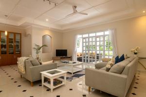 ein Wohnzimmer mit 2 Sofas und einem TV in der Unterkunft Villa Jasmin in Bel Ombre