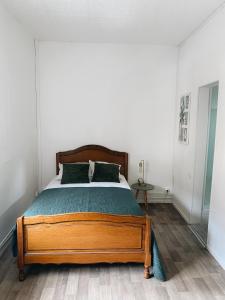 - une chambre avec un lit en bois dans l'établissement Maison cosy avec 3 chambres et 3 salles de bains, à Amiens