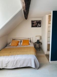 a bedroom with a bed with orange pillows at Maison cosy avec 3 chambres et 3 salles de bains in Amiens