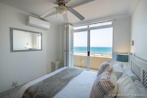 a bedroom with a bed with a view of the ocean at Cozumel 218 in Umdloti +29 photos