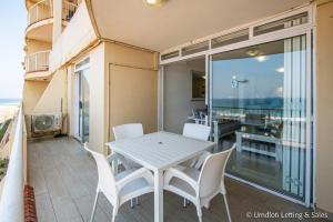a white table and chairs on a balcony with a view at Cozumel 218 in Umdloti