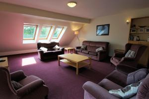 a living room with couches and chairs and a table at Osprey View in Lochearnhead