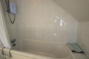 a white bathroom with a tub and a shower at Osprey View in Lochearnhead +21 photos