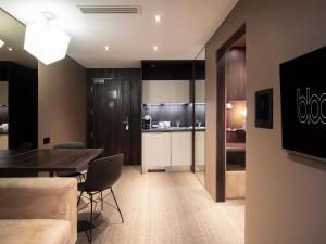 a living room with a table and a kitchen at Bloc Hotel Birmingham in Birmingham +21 photos