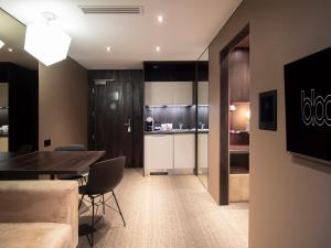a living room with a table and a kitchen at Bloc Hotel Birmingham in Birmingham