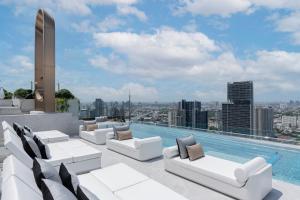 曼谷的住宿－ 曼谷素坤逸怡思得酒店，一个带白色家具的屋顶游泳池和一个游泳池