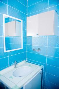 a blue bathroom with a sink and a mirror at CAB LFS SIPRES MOURTADA 3e ETAGE in Dakar