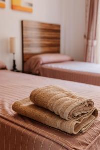 a stack of towels sitting on top of a bed at Apartamentos Turisticos Playa Principe in La Manga del Mar Menor