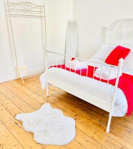 a bedroom with a white bed with a red blanket at Southsea stays in Portsmouth