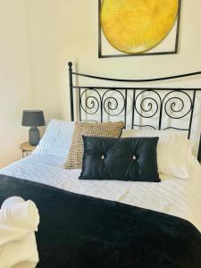 a bedroom with a black and white bed with two pillows at Southsea stays in Portsmouth