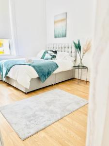 a white bedroom with a bed and a rug at Southsea stays in Portsmouth