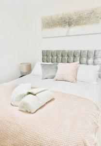 a large bed with white sheets and pink pillows at Southsea stays in Portsmouth